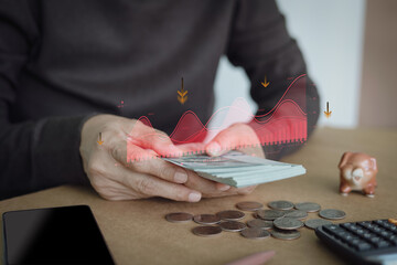 Hands counting dollar bills with a downward red trend graph overlay. Concept of financial risk, economic recession, inflation impact, loss of savings, and urgent money management during a crisis.