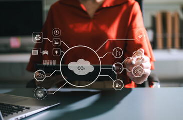 Woman using futuristic interface with smart tech and mobile to manage ESG, clean energy, and sustainability data. in office