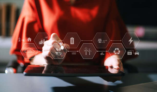 Woman using futuristic interface with smart tech and mobile to manage ESG, clean energy, and sustainability data. in office