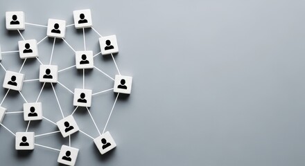 An overhead view of interconnected white blocks, each with a person icon, forming a complex network on a grey background