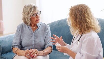 Doctor holding a medicine bottle while explaining a prescription to a senior woman during a home healthcare visit, fostering trust and comfort