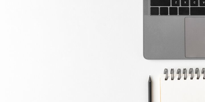 Cropped gray laptop with blank notepad and pencil on white office background - Powered by Adobe