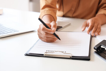 Young woman with laptop filling tax form at home, closeup