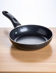 A deep, round nonstick pan with a long handle placed on a wooden countertop, suitable for stir-frying or saut&eacute;ing.