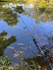 Fishing Rod Reflection: A close-up shot of a fishing rod with reflection in lake.