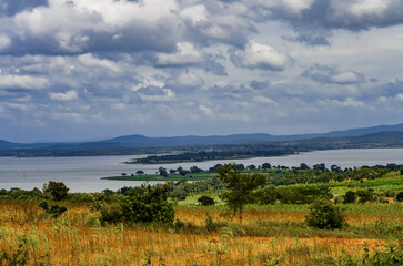 Lakeside Valley under Cloudy Sky
