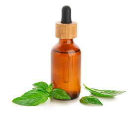 Bottle of basil essential oil isolated on white background, closeup
