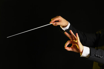 Fototapeta premium Hands of male conductor with baton on black background
