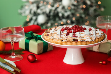 Stylish table setting for Christmas dinner with delicious cranberry pie, decor and gift boxes