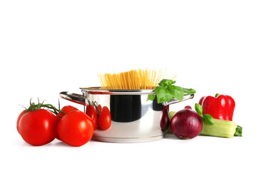 Cooking pot with different vegetables and pasta on white background