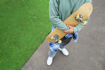 Young man with skateboard at skatepark, closeup