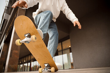 Legs of young man with skateboard outdoors, closeup