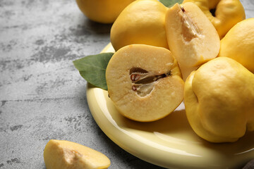 Plate with sweet ripe quinces on grey background, closeup