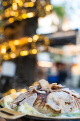 Delight in sizzling hot Moo Kata, a traditional Thai barbecue experience featuring an assortment of marinated meats, fresh vegetables, and savory dipping sauces