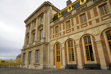 Exterior of the Palace of Versailles, showcasing its grand baroque architecture, ornate faades, gilded details,  majestic royal residence that reflects the opulence historic grandeur of French royalty