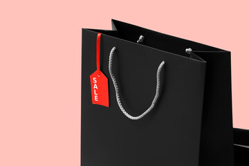 Shopping bag with tag on pink background. Black Friday sale