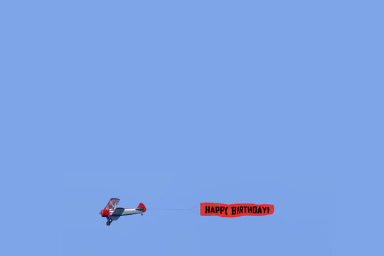 Happy Birthday banner on aeroplane Aviation displays Air show Birthday sign birthday greetings blue sky background for text copy