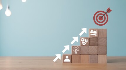 Wooden blocks illustrate the steps to achieve a defined objective symbolized by a dartboard