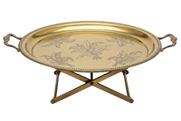 Golden brass serving tray with floral engraving on folding stand isolated on transparent background