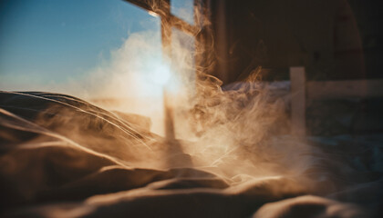 Golden sunset light filtering through swirling dust over sandy terrain.