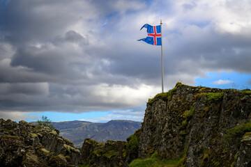 Thingvellir National Park Icelandic flag on cliff edge over the tectonic rift valley