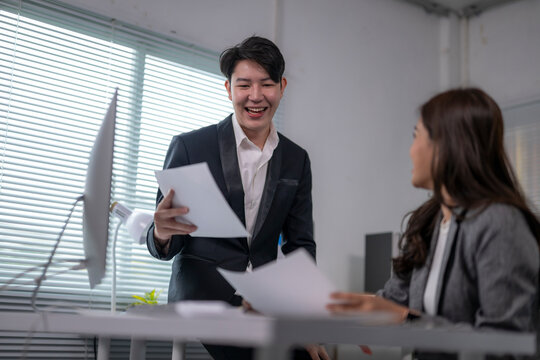 Business partners discussing and sharing documents in office meeting - Powered by Adobe