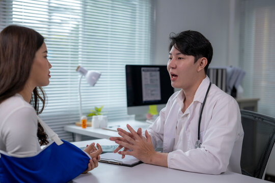 Doctor explaining treatment to patient with arm in sling