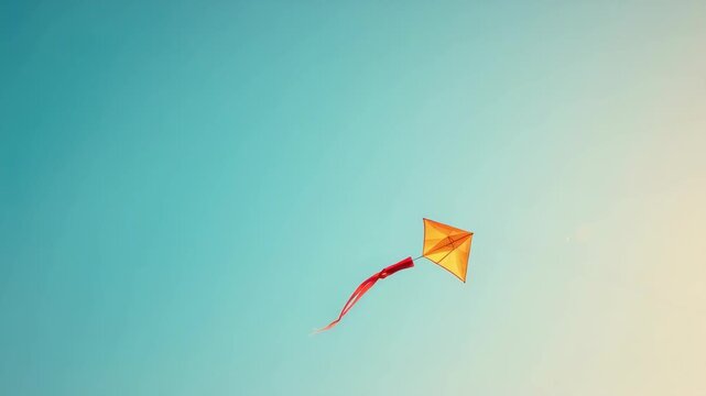 Orange kite flying in clear blue sky