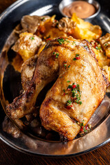 Roasted chicken leg with crispy potatoes and herbs