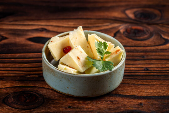 Spiced cheese cubes in rustic ceramic bowl