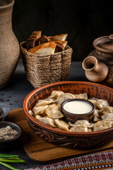 Ukrainian dumplings with sour cream in rustic setting