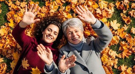 Smiling women lying on leaves in autumn season friendship happiness