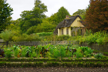 The Hameau de la Reine at Trianon, Marie Antoinette’s pastoral estate with charming rustic cottage buildings, landscaped flower gardens, showcasing  historic elegance and beauty of French countryside © faestock