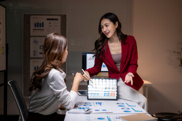 Businesswomen analyzing data together during office meeting presenting ideas