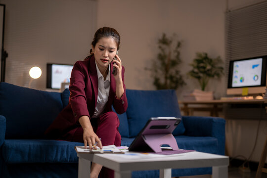 Businesswoman talking on phone working late at night