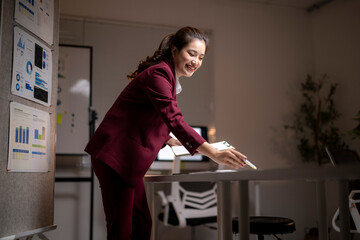 Asian businesswoman smiling working late in office