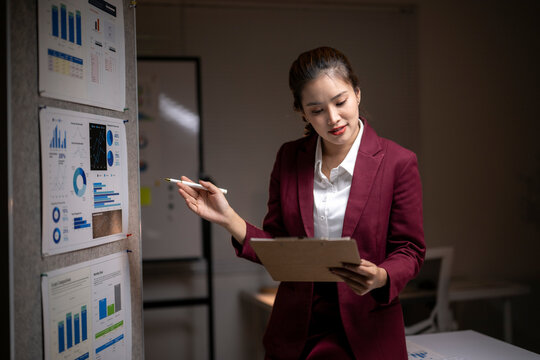 Businesswoman analyzing data on board with charts