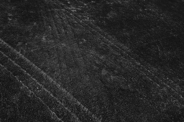 Close up black tire marks on cement floor.