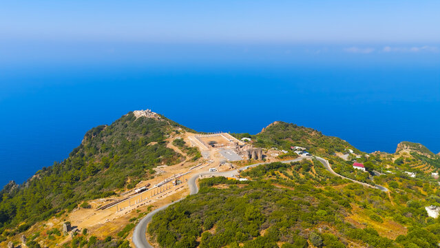 Guneykoy, Antalya, Turkey. Aerial drone view of ancient city Antiochia ad Cragum with colonnaded street, ongoing excavations and hilltop fortress on cliff edge during bright sunny day.. Aerial View