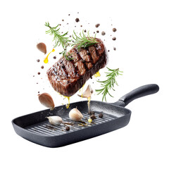 Grilled steak, garlic, herbs, and spices flying over pan