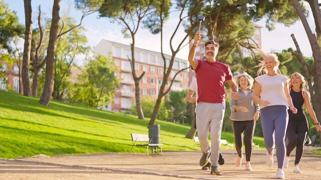 Group of active seniors running while taking a selfie - Powered by Adobe