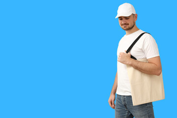 Man displays casual style by holding a tote bag while standing