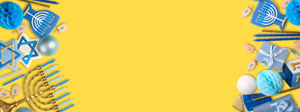 Colorful Hanukkah decorations arranged on bright yellow surface