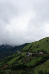 Naklejka premium Mountain Village on Green Hillside under Cloudy Sky in Sa Pa, Vietnam