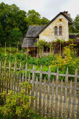 The Hameau de la Reine at Trianon, Marie Antoinette’s pastoral estate with charming rustic cottage buildings, landscaped flower gardens, showcasing  historic elegance and beauty of French countryside © faestock