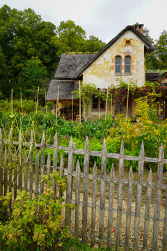 The Hameau de la Reine at Trianon, Marie Antoinette&rsquo;s pastoral estate with charming rustic cottage buildings, landscaped flower gardens, showcasing  historic elegance and beauty of French countryside