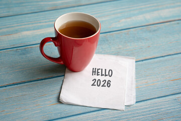 Hello 2026 message on a white napkin next to a cup of coffee.