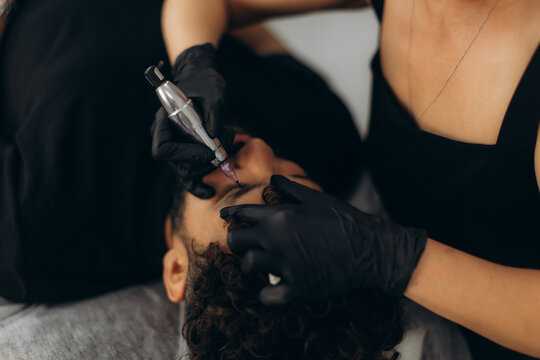 Man receiving microblading permanent makeup eyebrow treatment