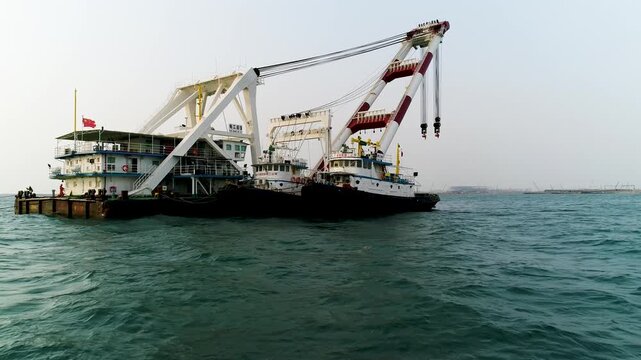 Large Heavy-Lift Construction Vessel with Dual Cranes in Harbor