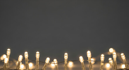 String of Glowing Warm White Fairy Lights Creating a Magical Border on a Solid Charcoal Gray Background